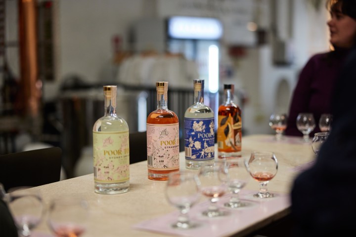 Bottles of various liquors on a table with tasting glasses.