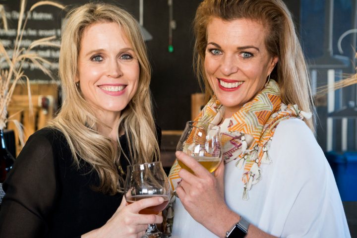 a woman holding a wine glass posing for the camera