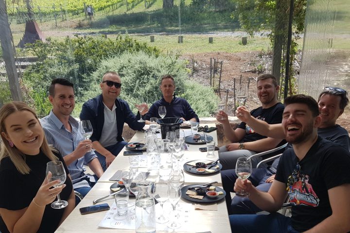 a group of people sitting at a picnic table posing for the camera