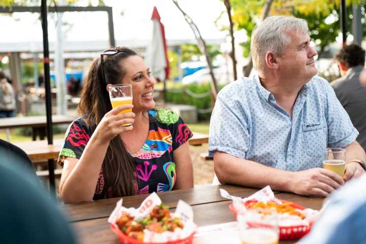 People enjoying drinks and food at an outdoor table.