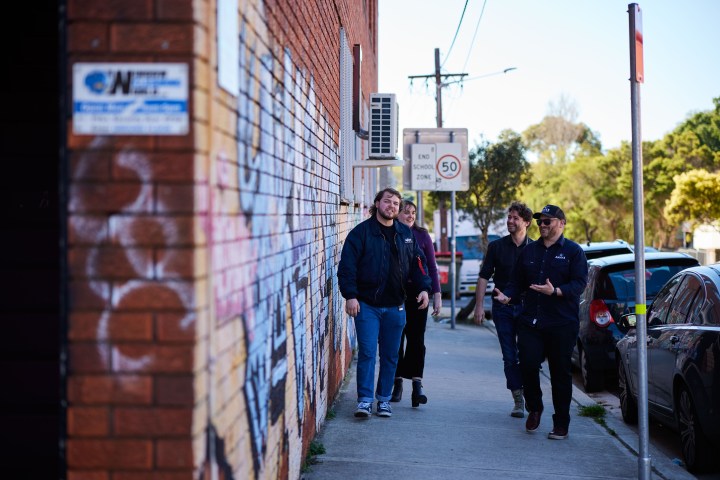 a group of people standing on a sidewalk