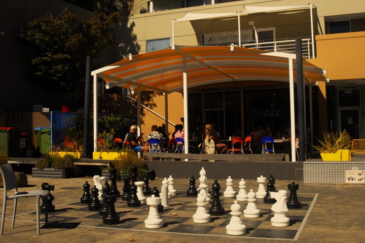 a group of people sitting at a table in front of a building
