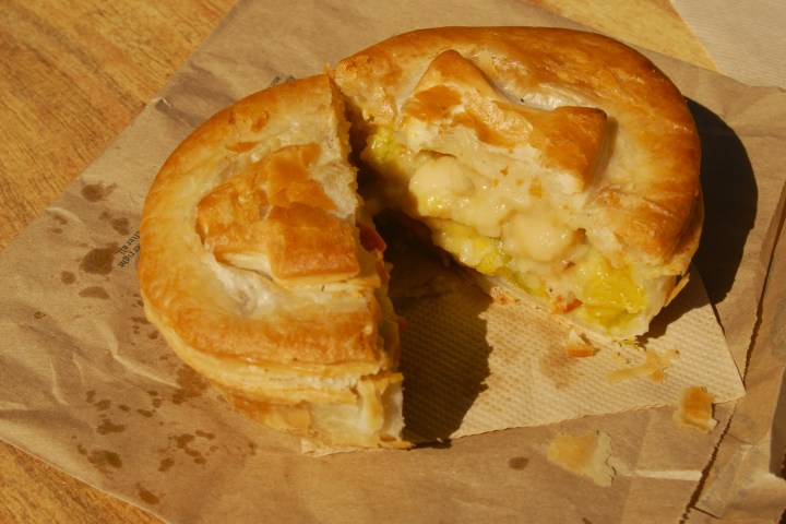 a half eaten doughnut sitting on top of a wooden table